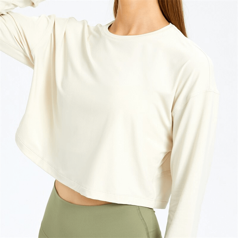 Stylish sport short women's sweatshirt with long sleeves, perfect for yoga. Breathable spandex material in ivory, model wears olive leggings.